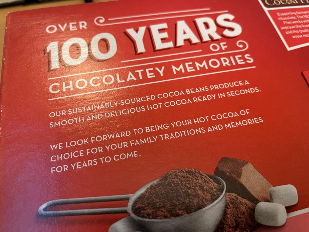 Achterkant van de verpakking: "Over 100 years of chocolatey memories. 

Our sustainably sourced cocoa beans produce a smooth and delicious hot cocoa ready in seconds.

We look forward to being your hot cocoa of choice for your family traditions and memories for years to come."